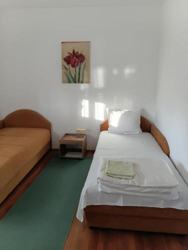 a small bedroom with a bed and a couch at Privatni smeštaj Nanica in Mataruška Banja