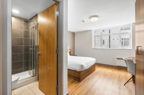a bedroom with a bed and a bathroom with a shower at The Mitre Hotel Brighton in Brighton & Hove