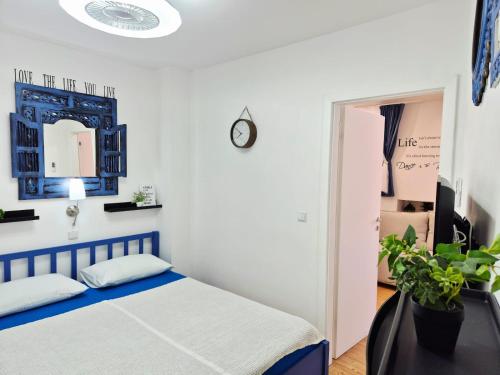 a bedroom with a bed and a clock on the wall at Apartments Sandra in the historical center of the city in Supetar