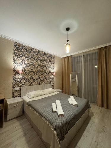 a bedroom with a bed with two towels on it at PAPILLON in Chakvi
