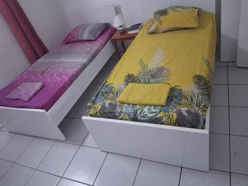 a small room with a bed and a couch at Logement meublé proche CHUM, idéal stagiaires et professionnels in Le Lamentin