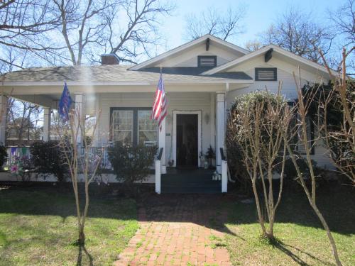a white house with two flags in the yard at The Carriage House in Jefferson