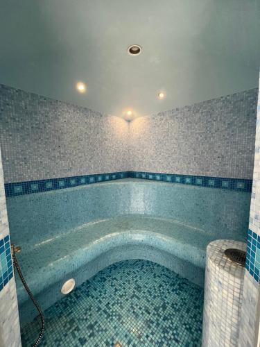 a swimming pool in a bathroom with blue tiles at Just Chill in Riga