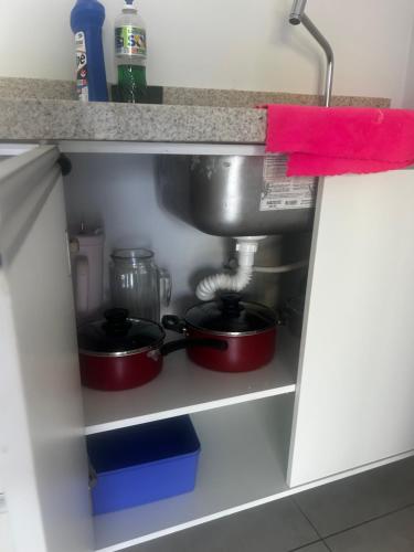 two pots and pans in a kitchen cabinet at Florence Nightingale in Sorriso