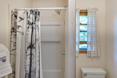 a bathroom with a shower curtain and a toilet at Lake Champlain On-Site! Waterfront Studio w/ Dock in Willsboro