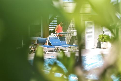a woman standing on a treadmill next to a swimming pool at Hotel Ascot & Spa in Rimini
