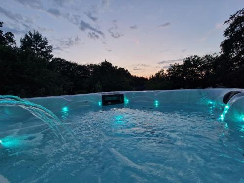 a swimming pool with lights in the water at Eiflia- Im Ourtal in Burg-Reuland