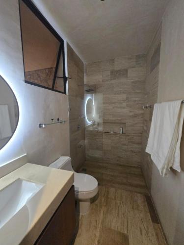 a bathroom with a toilet and a sink and a mirror at Beachfront , alberca y terraza in Telchac Puerto
