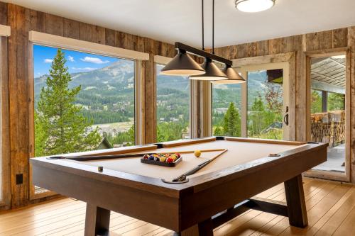 a pool table in a room with a mountain view at Lone Mountain Lookout in Big Sky