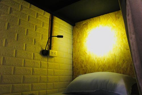 a bedroom with a brick wall and a window at Crew Bangkok Hostel in Bangkok