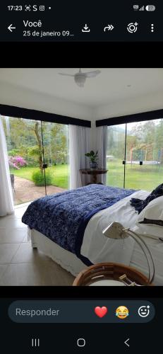 a page of a bedroom with a bed and a window at Zen in Itaipava