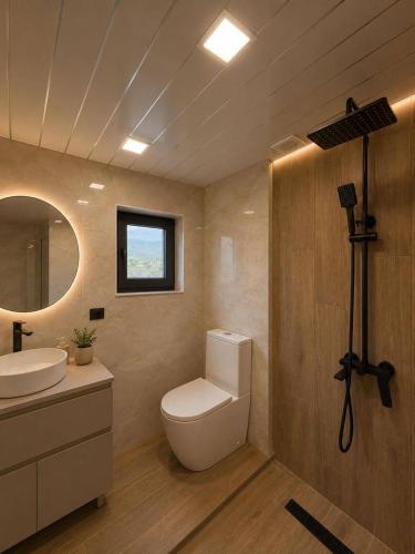 a bathroom with a toilet and a sink and a mirror at Highland Hils in Garni