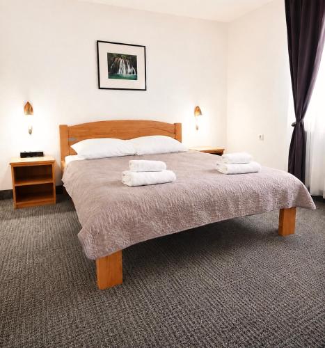 a bedroom with a bed with two towels on it at Guest House Kovačević in Korenica