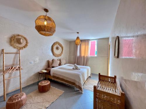 a bedroom with a bed and a couch at Little Palm Camp in Imsouane