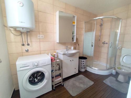 a bathroom with a washing machine and a sink at Apartman Dream in Livno