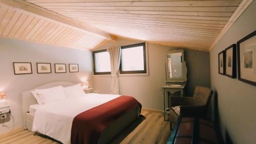 a bedroom with a bed and a television in it at Quinta de Linhares in Oliveira
