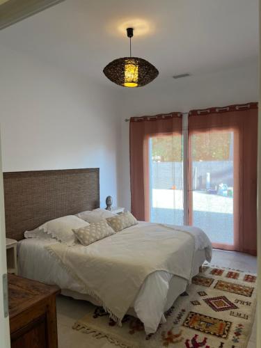 a bedroom with a bed and a large window at Gîte du Grand Frêne in Nérac