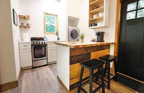 a kitchen with a counter and two stools in it at Tiny Tarheel Cozy Retreat Near UNC-Tiny House in Chapel Hill