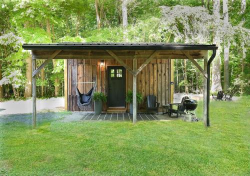 a shed with a green door in a yard at Tiny Tarheel Cozy Retreat Near UNC-Tiny House in Chapel Hill