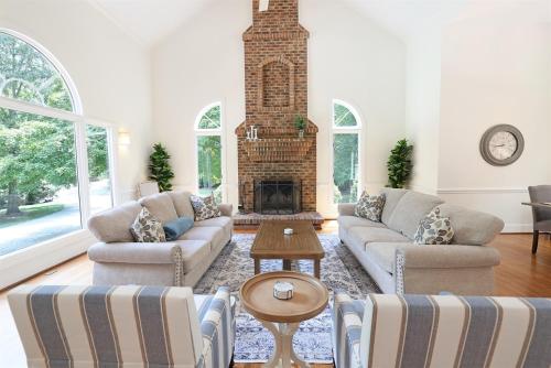 a living room with a couch and a fireplace at Lg Pool House w Hot Tub Central to RTPPool OPEN in Durham