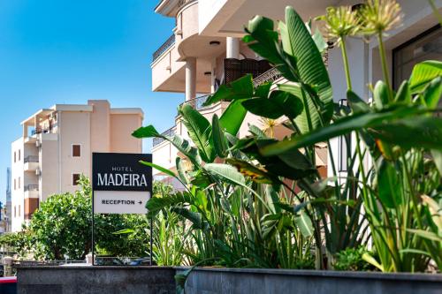 a sign in front of a building with plants at Hotel Madeira in Budva