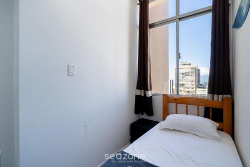 a small bedroom with a bed and a window at Apt in Downtown Floripa CAT0905 in Florianópolis