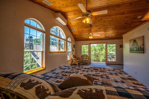 a large bedroom with a large bed and windows at Brier Escape in Bass Lake