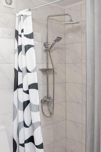 a shower with a black and white shower curtain at Котедж у Русина in Pilipets