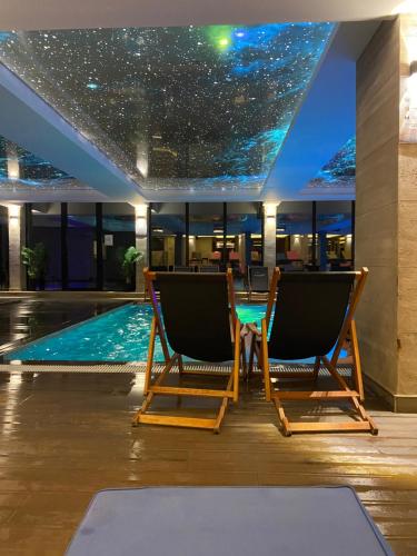 a room with two chairs and a swimming pool at NLux Nest Milmari in Kopaonik