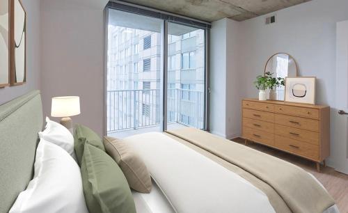 a bedroom with a large bed and a large window at SE Furnished Apartment in Atlanta