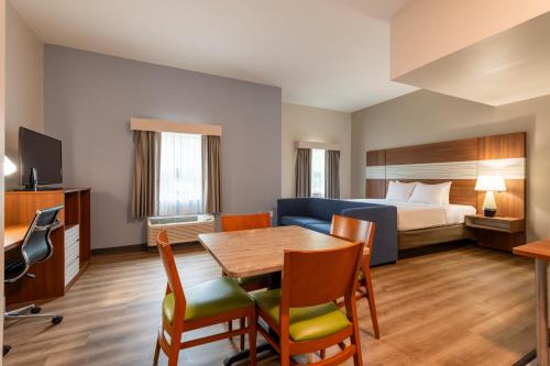 a hotel room with a bed and a table and chairs at Franklin Extended Stay Hotel in Franklin