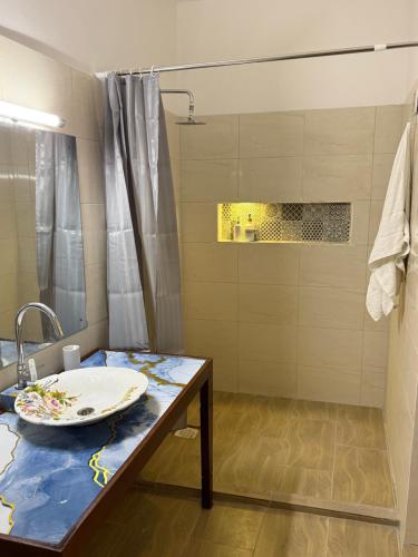 a bathroom with a sink and a table with a plate on it at Bakarani in Mombasa