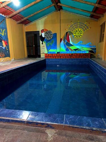 a swimming pool with a painting on the wall at Hostal el Vaquero in Chugchilán