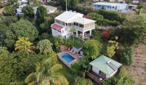 an aerial view of a house with a swimming pool at VillAnolis in Le Carbet