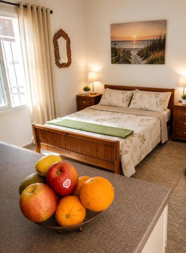 a bedroom with a bed and a bowl of fruit on a table at La Finca Roja 3 in Coín