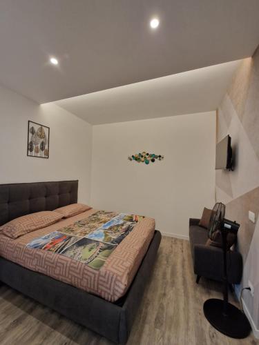 a bedroom with a bed and a chair at A 2 min dal Trenino Rosso Monolocale CLESSIDRA1 in Tirano