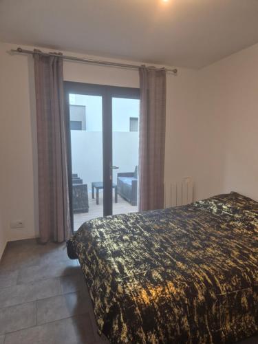a bedroom with a bed and a sliding glass door at Appartement avec terrasse in Vias