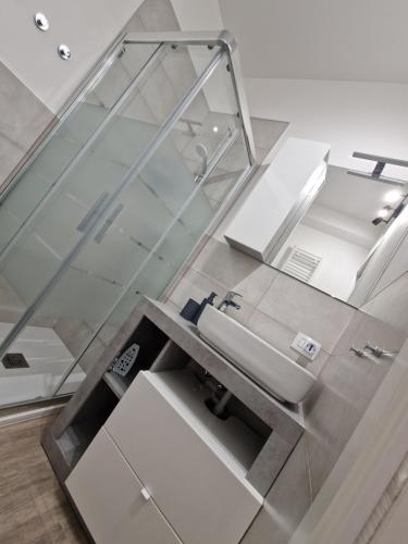 a bathroom with a sink and a glass wall at A 2 min dal Trenino Rosso Monolocale CLESSIDRA1 in Tirano
