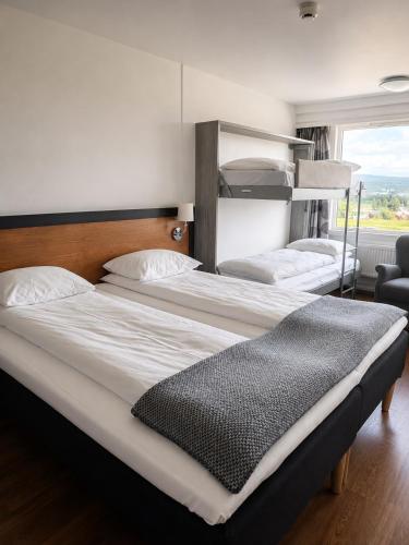 a couple of beds in a room with a window at Frichs Hotel Hamar in Hamar