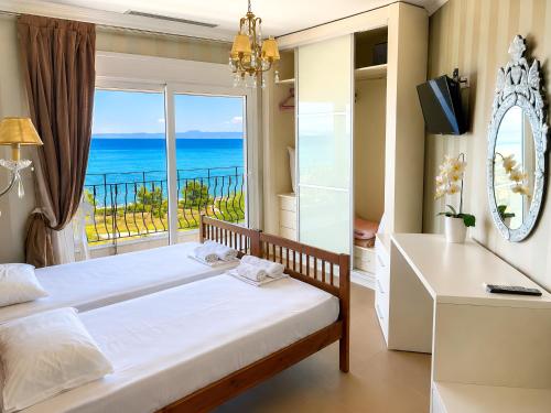 a bedroom with a bed and a view of the ocean at Plaza Hotel in Hanioti
