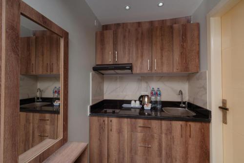 a kitchen with wooden cabinets and a sink at Aqua Fun Resort in Hurghada