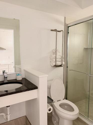 a bathroom with a toilet and a sink and a shower at Olympic Island Beach Resort in Wildwood Crest