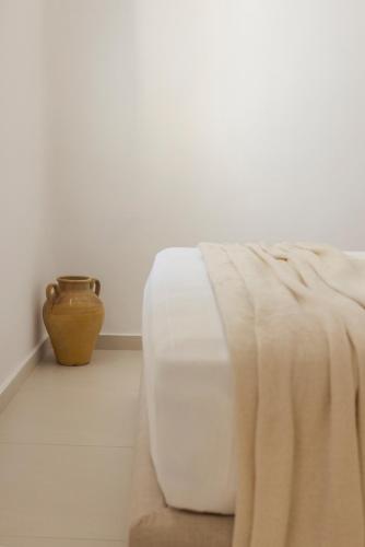 a white bed and a vase in a room at Ithaca Garden Villa, Kioni in Kiónion