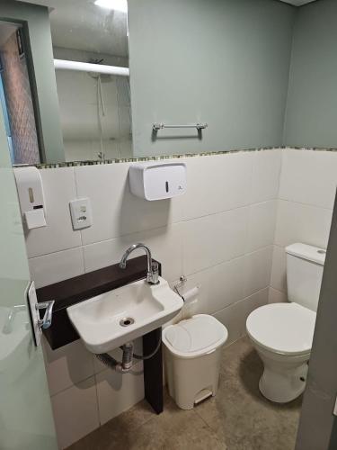 a bathroom with a sink and a toilet and a mirror at Recanto Grande Lago in Massaranduba