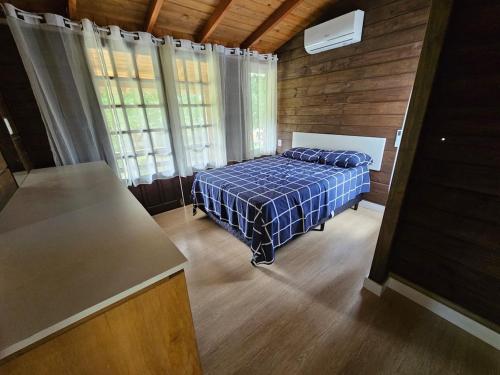 a bedroom with a bed in a room with windows at Recanto Grande Lago in Massaranduba