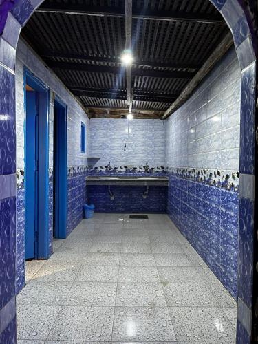 an empty bathroom with blue tiles on the walls at Salah boutique camp in Nuweiba