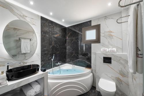 a bathroom with a tub and a toilet and a sink at Aphrodite of Thassos in Skala Marion