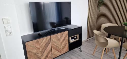 a tv in a room with a table and chairs at HomeComfort in Cologne