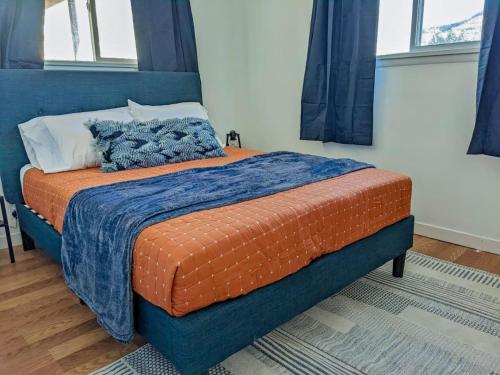 a bedroom with a bed with an orange blanket at Pet-Friendly Downtown Kanab Basecamp | Hot Tub in Kanab