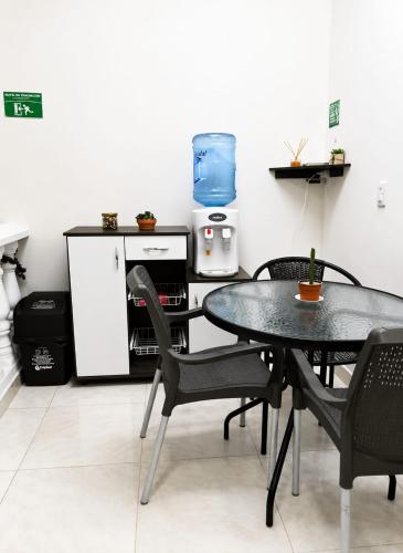 a table and chairs in a kitchen with a refrigerator at Hostal Mi Puerto in Puerto Triunfo